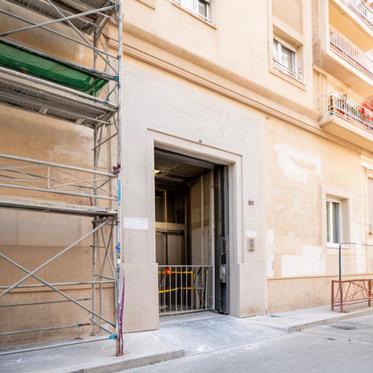 Portal de una comunidad residencial de Benicalap en Valencia durante una obra de ascensor y reparación de fachada